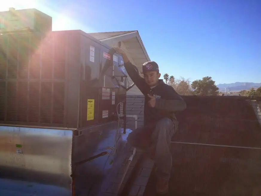 HVAC technician performing AC Tune-Up on a rooftop unit in Coppell